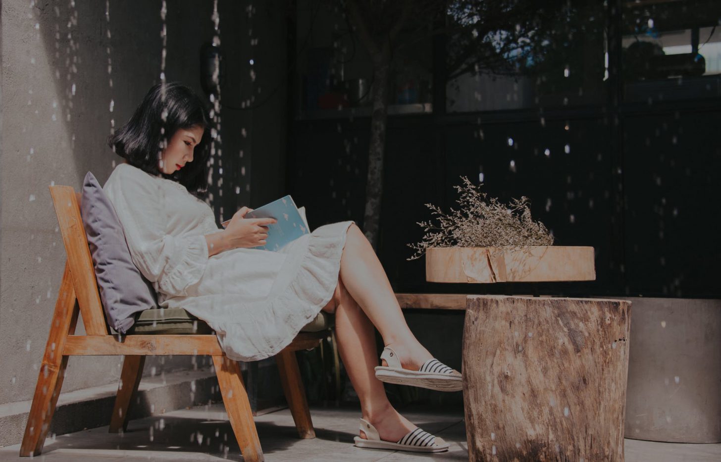 vrouw die alleen een boek leest in een café