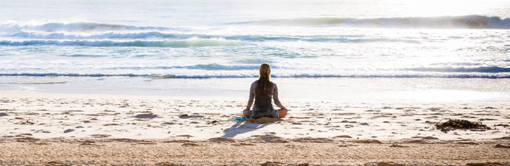 meisje doet kundalini yoga op strand