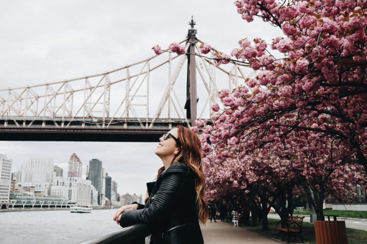 vrouw lacht voor brug en bloemen