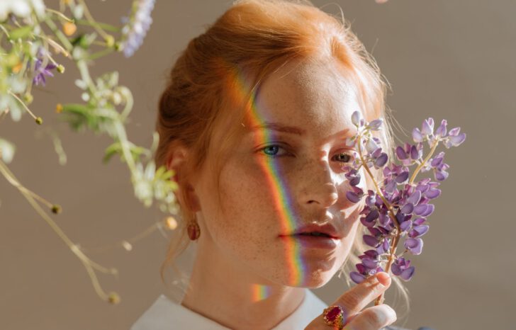 vrouw met regenboog op gezicht