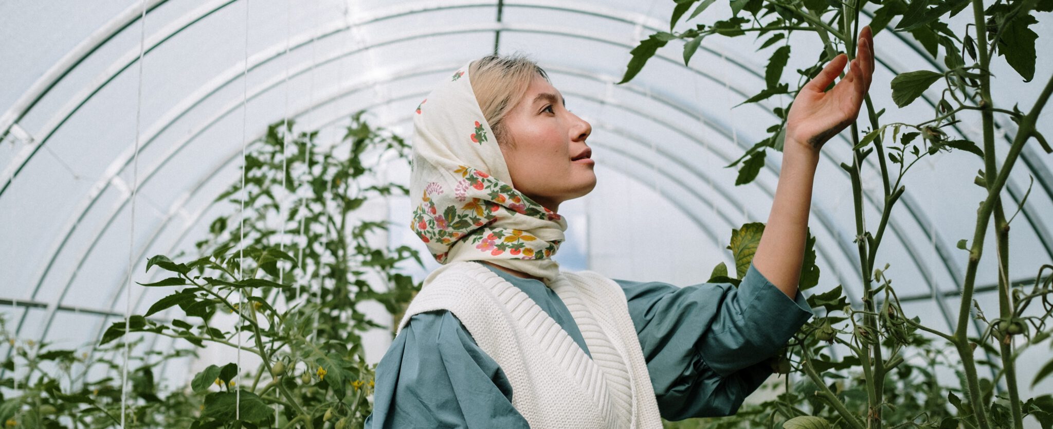 vrouw staat in plantenkas