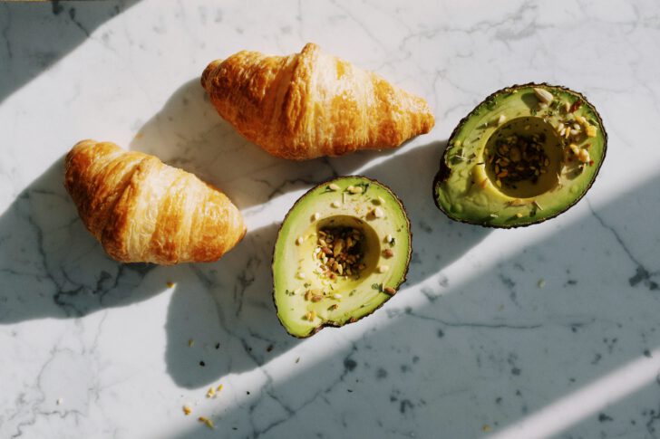 twee halve avocado's en 2 croissanten