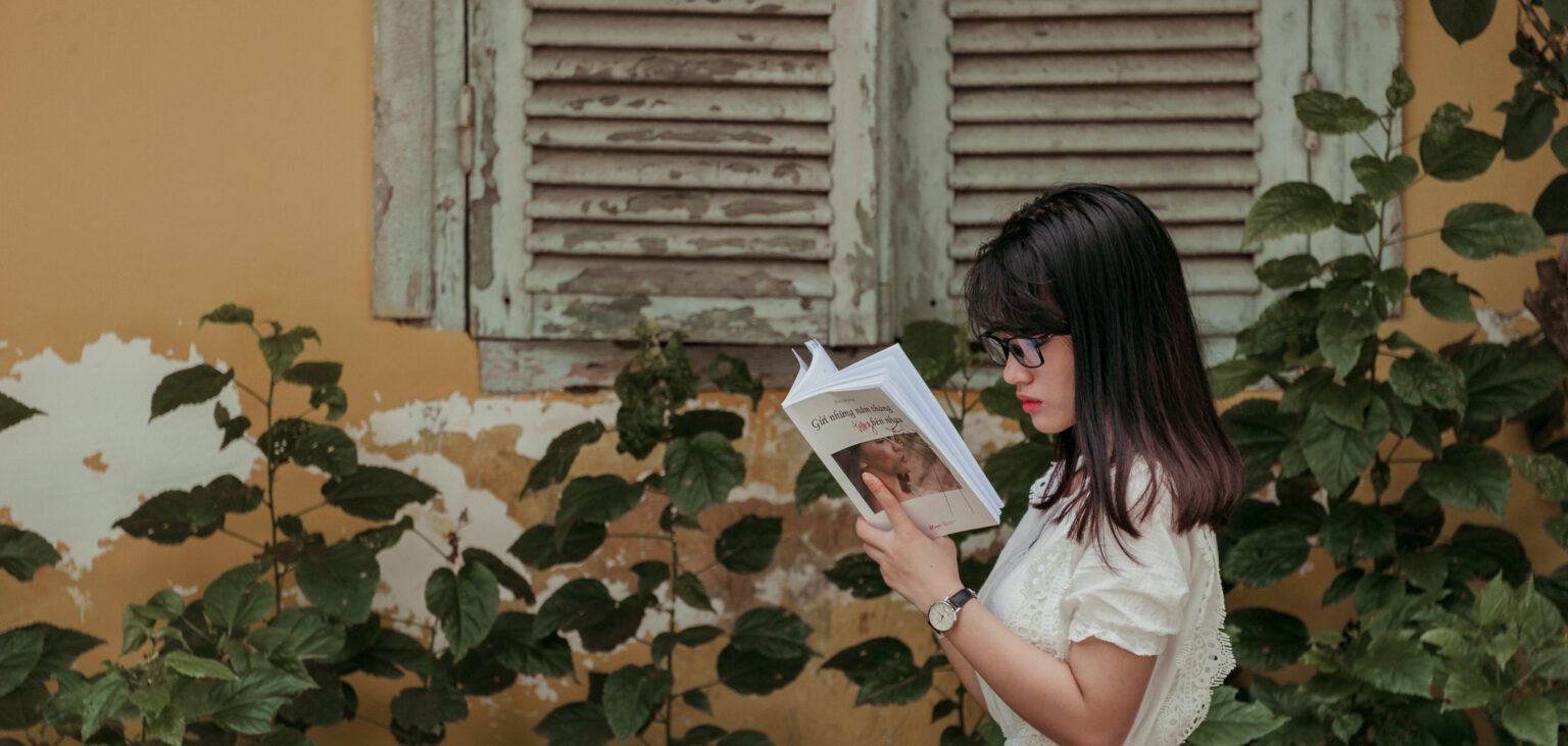 vrouw leest boek in de zon