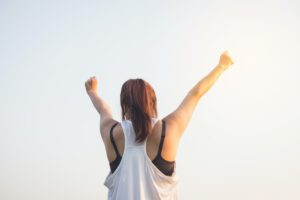 Vrouw in sportkleding die armen in de lucht steekt