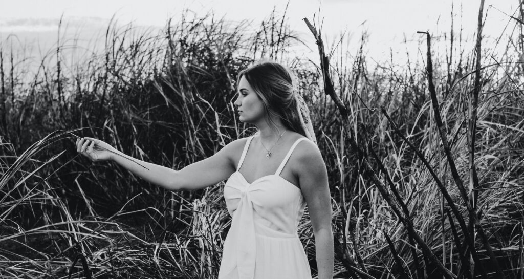 Zwart wit foto van vrouw die in een veld staat