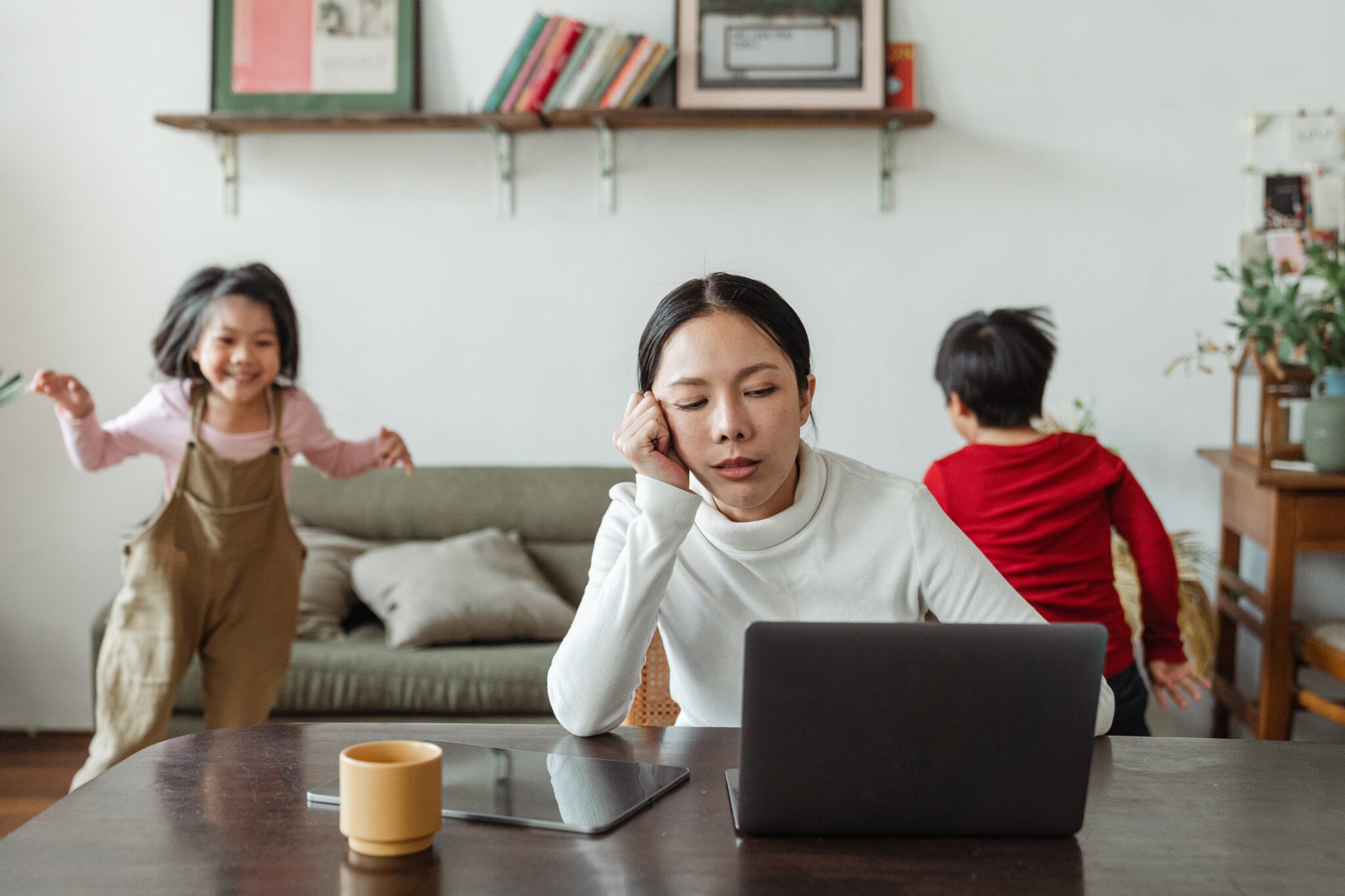 Vermoeide vrouw die thuiswerkt met twee kinderen