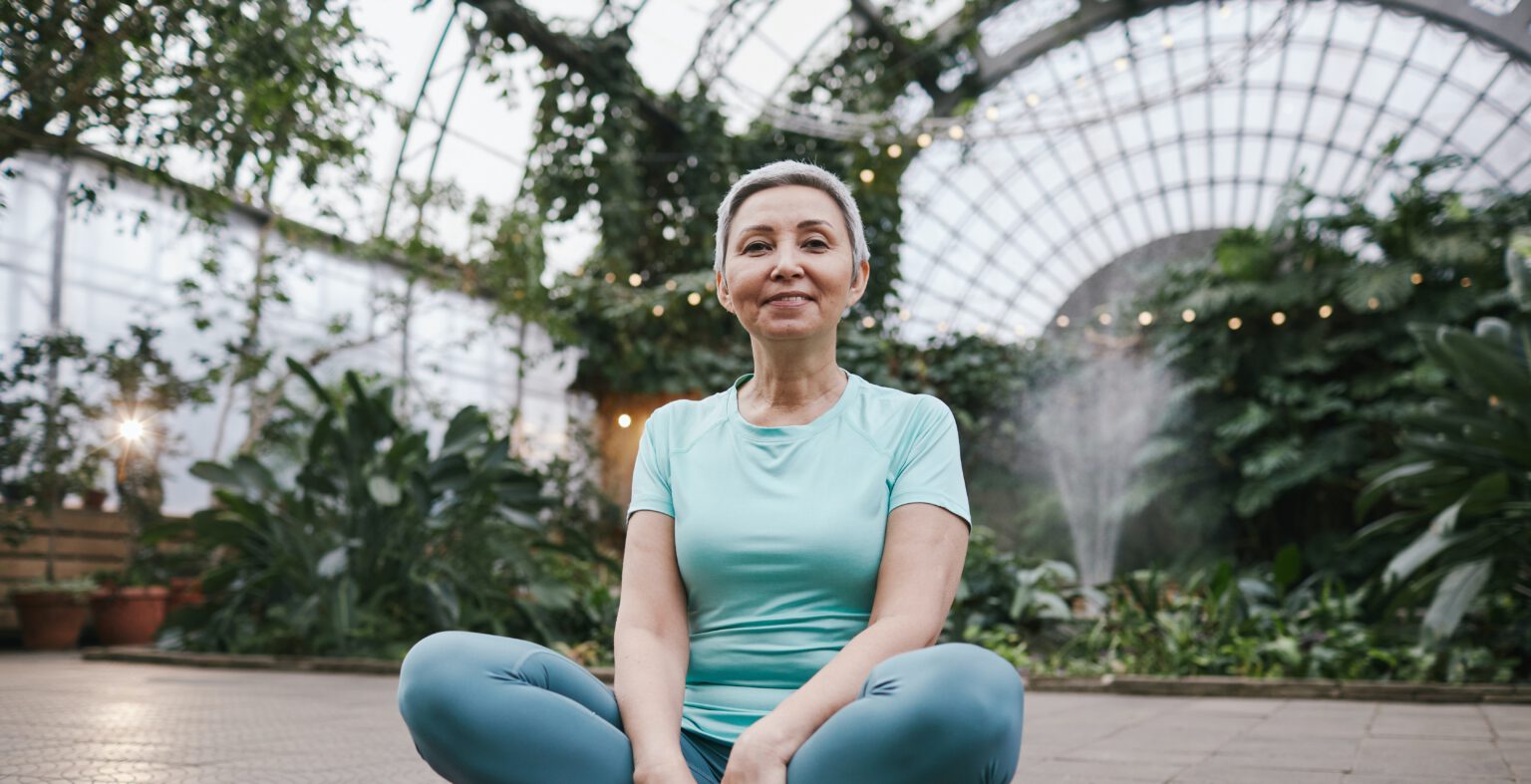 Vrouw zittend op yoga mat