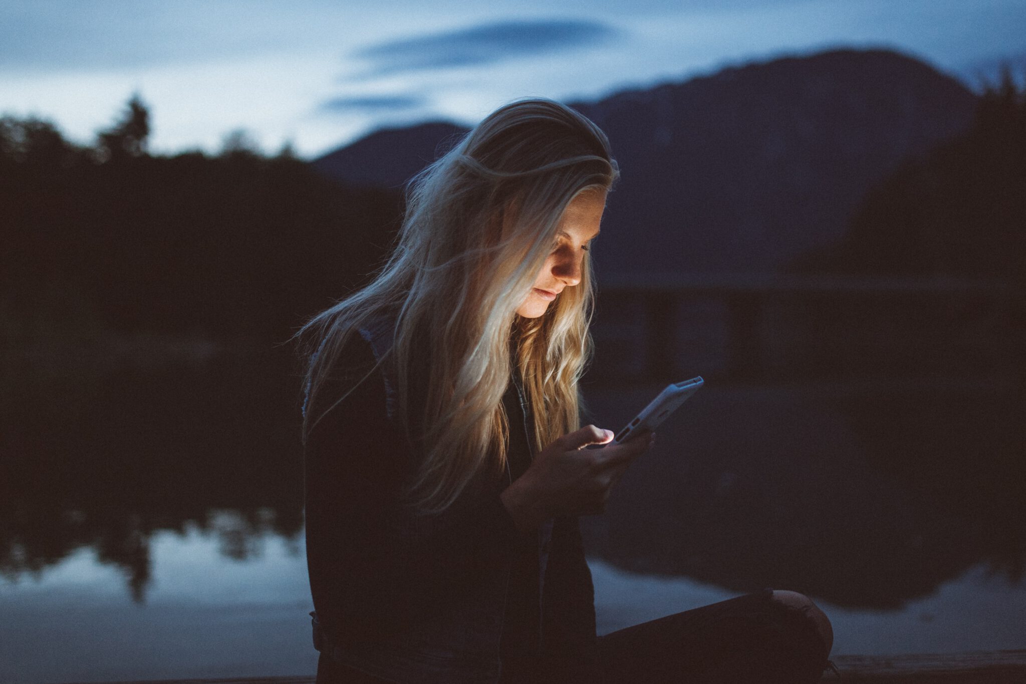 vrouw kijkt op telefoon in het donker