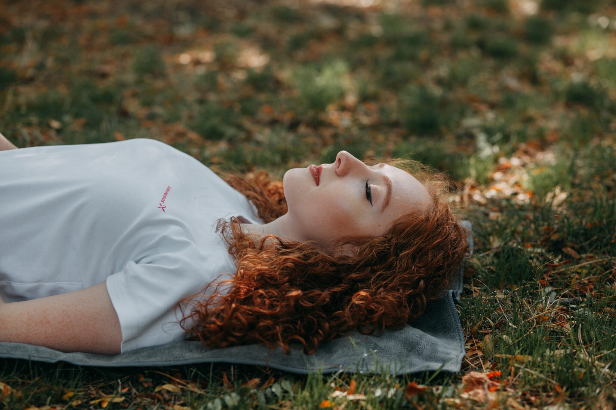 vrouw ligt in het gras met ogen dicht