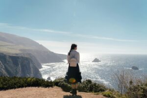 vrouw met backpack aan de kust